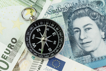 Direction of Europe and UK after Brexit negotiation concept, compass on Euro and UK Pound banknotes