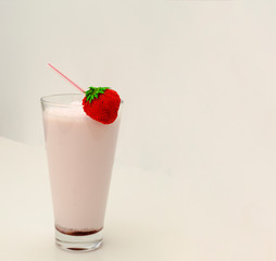 Strawberry cocktail or milk shake in a glass decorated with strawberries on the table. Healthy food for breakfast and snacks.