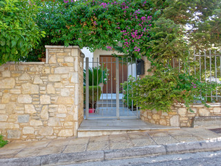 Fototapeta na wymiar stone fence and vintage house main entrance, Athens Greece