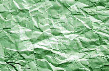 Crumpled sheet of paper with blur effect in green color.