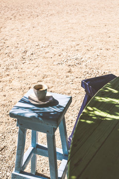Cup of coffee on a chair on the beach in a cafe.