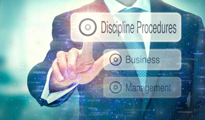 A businessman selecting a button on a futuristic display with a Discipline Procedures concept written on it.