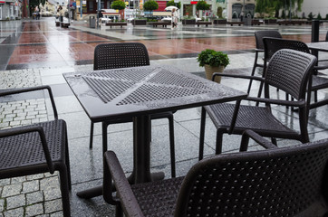 A CITY IN THE RAIN - Wet tables and cafe chairs on the town hall square