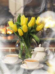 A bouquet of yellow tulips in a vase in the interior of a retro room. Retro interior with bouquet of tulips.