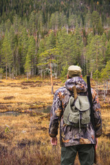 Hunter with a backpack and a gun