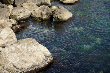 Fototapeta na wymiar large stones in the water by the sea