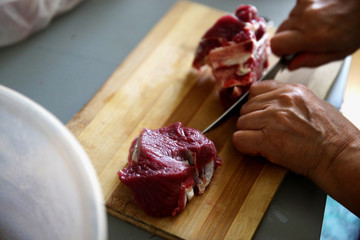 Cutting meat with a knife.