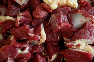 Close up view of fresh finely chopped meat cubes. Red meat small steaks with whitish meat fat. 
