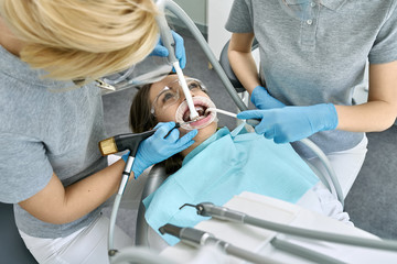 Pretty woman's teeth cleaning in dental clinic