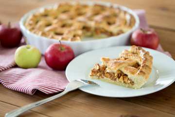 food, culinary and baking concept - close up of apple pie and fork on plate