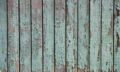 fence of boards painted green in places worn