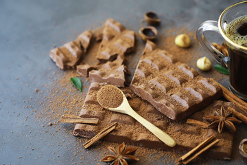 A bar of milk chocolate on the table. Chocolate with nuts and cinnamon.