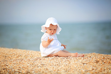Little girl in a white hat near the sea