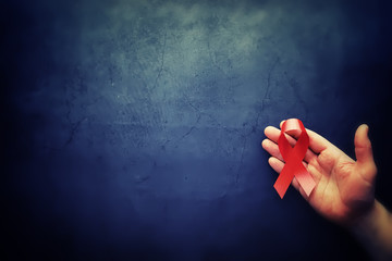 Symbol of human immunodeficiency virus disease. Red ribbon. A helping hand and support.