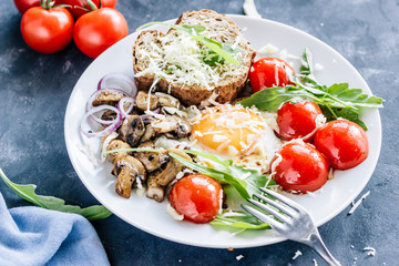 Breakfast fried egg with mushrooms champignons and arugula