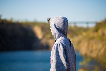 Back view of young man looking at the beautiful view at the lake. Travel and psychology concept. copy space