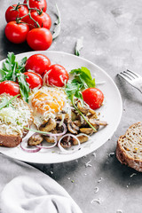 Breakfast fried egg with mushrooms champignons and arugula