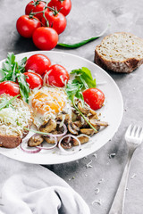 Breakfast fried egg with mushrooms champignons and arugula