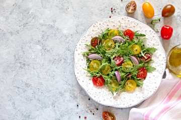 Fresh salad with vegetables on light background. Top view with copy space.