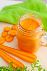 Glasses of carrot juice with vegetables on table close up