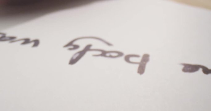Closeup motion shoot of marker writing on the paper. Handwriting on the sheet