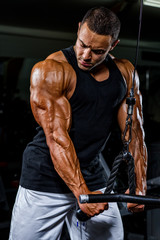 Body Builder Exercise Triceps at the Gym. Performing Triceps Rope Pushdowns