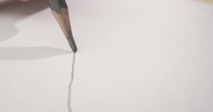 Closeup shoot of pencil drawing a line on the paper. Work of a creative artist