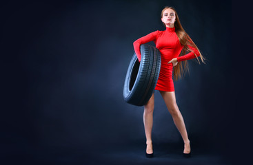 Woman holding tire in her hands. Car tires background. Banner with copy space. .