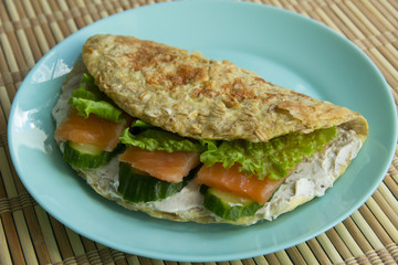 Sandwich of oatmeal, red fish salmon, cucumber, cheese, lettuce