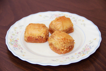 traditional Turkish puff sweetness baklava with nuts on white plate
