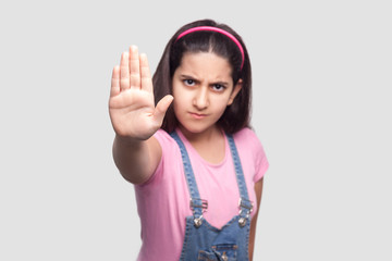 Stop. Portrait of angry beautiful brunette young girl in casual, pink t-shirt and blue denim...