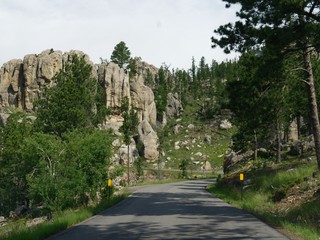 Scenic drive along a winding road with dramatic granite formations at Needles Highway in South Dakota.