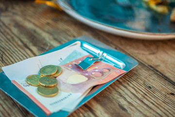 payment on the bill in a cafe on a plate on a wooden table