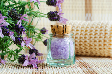 Obraz na płótnie Canvas Vintage glass bottle with aroma lavender bath salt (foot soak). Topped lavender flowers close up. DIY beauty treatments and spa concept. Copy space. 