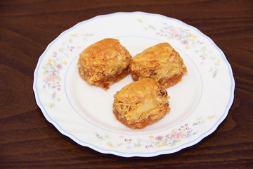 traditional Turkish puff sweetness baklava with nuts on white plate