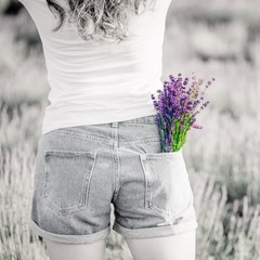 Bouquet of purple lavender flowers in the jeans pocket. Black and white photo, bright bouquet. Copy space