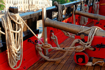 Fototapeta na wymiar Historical cannon of an old wooden sailboat. Details deck of the ship.