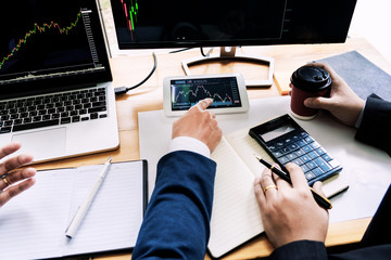 Team of stockbrokers Discussing with display screens Analyzing data, graphs and reports of stock market trading for investment