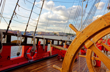 Helm wheel of an old wooden sailboat. Details of the deck of the ship