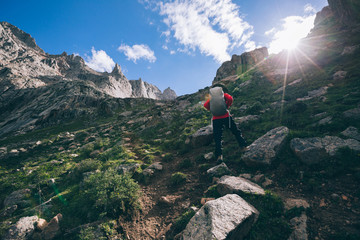 Woman hiker hiking at high altitude mountains