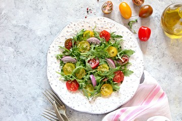 Fresh salad with vegetables on light background. Top view with copy space.