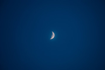 Obraz na płótnie Canvas Evening moon in the center of the blue sky