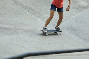 Fototapeta premium Female skateboarder skateboarding at skatepark