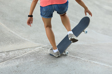 Fototapeta premium Female skateboarder skateboarding at skatepark
