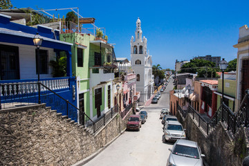 Hostos street, Santo Domingo, Dominican Republic. Beautiful street goes down in the colonial zone. view of Santuario Nuestra Señora de la Altagracia - obrazy, fototapety, plakaty