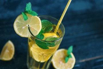Summer refreshing lemonade with lemon and mint on a wooden table close-up
