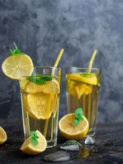 Summer refreshing lemonade with lemon and mint on a wooden table close-up
