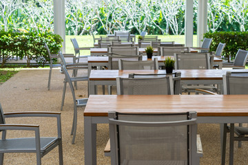 wooden and metal tables and chairs with garden.