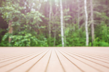 Summer forest background - in the foreground a wooden surface, in the background - a blurred...