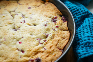 freshly baked cherry pie in a baking dish with a beautiful crafting blue towel